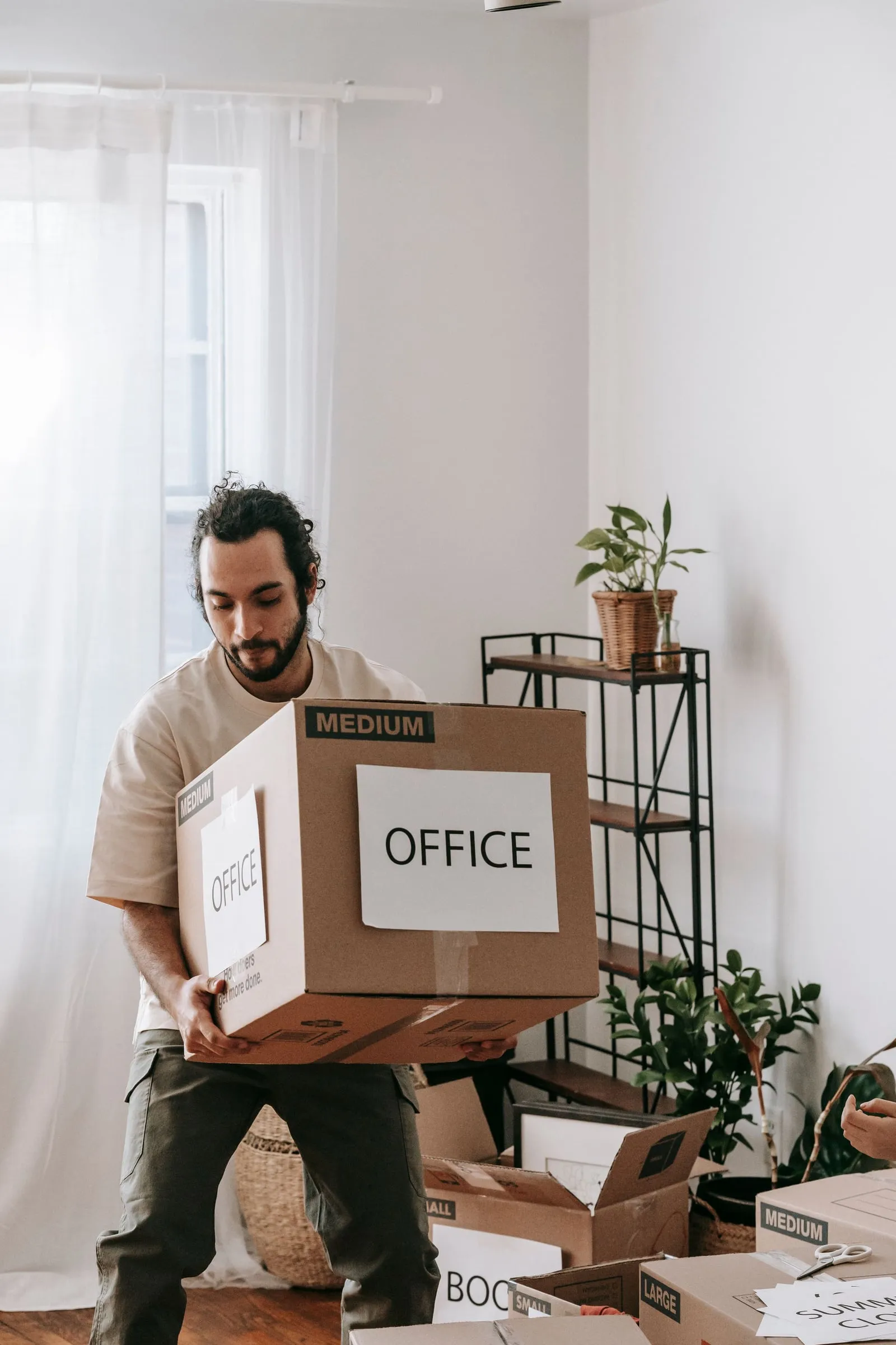 A mover carrying a packed box labelled "Office"